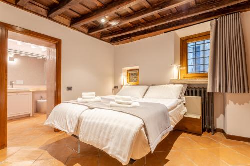Suite Italy Roma في روما: غرفة نوم كبيرة مع سرير كبير مع ملاءات بيضاء