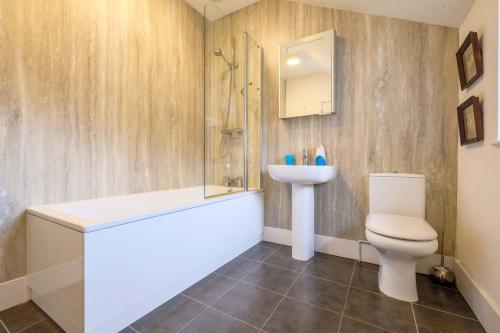a bathroom with a toilet and a sink and a shower at Beaver Cottage in Aldeburgh