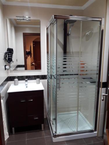 a bathroom with a glass shower and a sink at Apartamento Dreams in Vigo