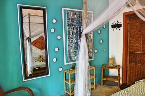 a bedroom with a blue wall with mirrors at The Happy Bird B&B in Hoi An