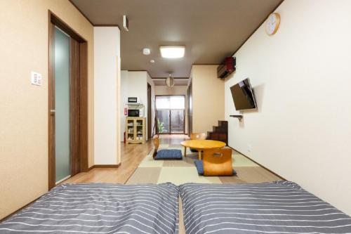 京町屋楓 Kyomachiya KAEDE في كيوتو: غرفة نوم بسرير وطاولة في غرفة