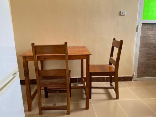 a wooden table with two chairs and a table and a table and a chair at Village View Hostel in Chanjani