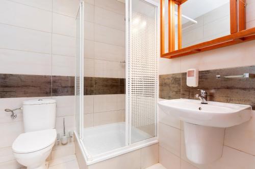 a bathroom with a toilet and a sink and a shower at Spa Bagiński & Chabinka in Międzyzdroje