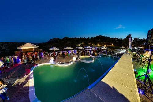 a group of people standing around a swimming pool at Sa Dom'e Malloru in Burcèi
