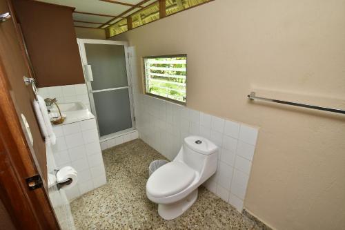a bathroom with a toilet and a sink at Hotel Tikal Inn in Tikal