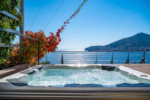 a hot tub on a balcony with a view of the water at Dukley Hotel & Resort in Budva