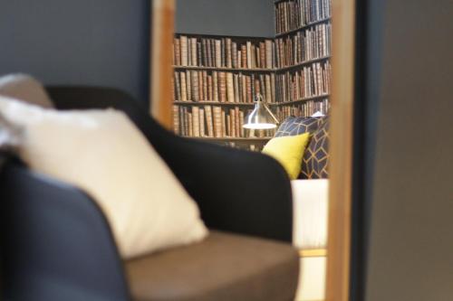 a mirror reflection of a couch and a book shelf with books at Procyon Boutique & Suites in Ponta Delgada