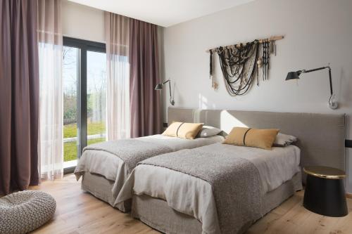 two beds in a bedroom with a window at Villa Ulmus in Karojba