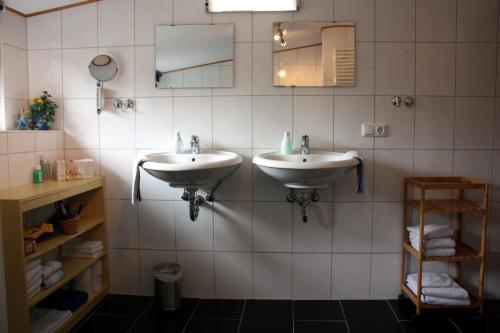 a bathroom with two sinks and a mirror at Haus Erika in Hemmoor