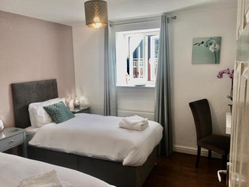 ein Schlafzimmer mit zwei Betten und einem Fenster in der Unterkunft The Orchid-Central Beeston-Private Apartment-SmartTV-Free Wi-Fi-Tram-Parking in Nottingham