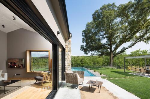 an open living room with a view of a yard at Villa Ulmus in Karojba