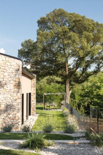 a stone building with a tree and a goal at Villa Ulmus in Karojba