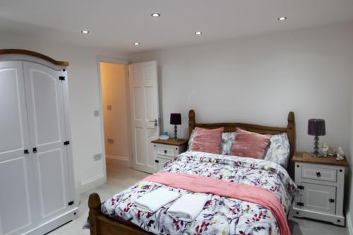 a bedroom with a bed and two night stands at NEWLY REFURBISHED 2 BEDROOM APARTMENT IN THE HEART OF GREENWICH in London