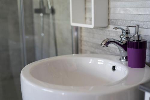a white bathroom sink with a purple cup on it at Hôtes'Antic Provence in Lorgues