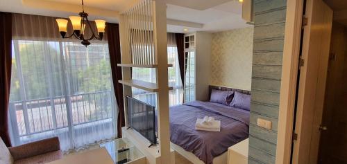 a small room with a bed and a balcony at Cozy near beach 200m with toproof pool at Patio Bangsaen in Ban Bang Saen (1)