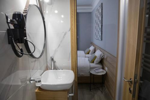 a bathroom with a sink and a mirror and a bed at Alexandros in Giannitsa