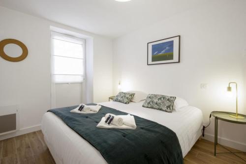 une chambre blanche avec un lit avec des serviettes dessus dans l'établissement Appartement Painel - 3 étoiles - Welkeys, à Biarritz
