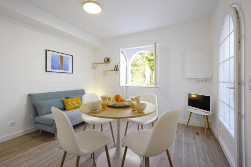 un salon avec une table, des chaises et un canapé dans l'établissement Appartement Painel - 3 étoiles - Welkeys, à Biarritz