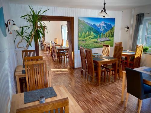 une salle à manger avec des tables et des chaises ainsi qu'une peinture murale. dans l'établissement Landhaus Tauplitz, à Tauplitz