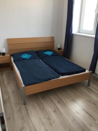 sypialnia z łóżkiem z niebieską pościelą i oknem w obiekcie Apartmán č.1 Haliganda*** w Liptowskim Gródku