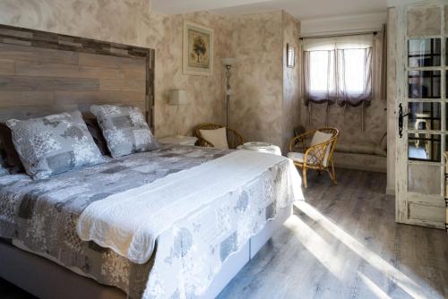 a bedroom with a large bed with a wooden headboard at Hôtes'Antic Provence in Lorgues
