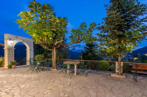 a patio with a table and chairs and trees at Hotel Makkas in Kréntis