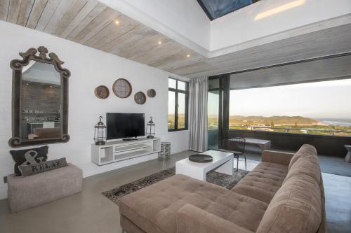 a living room with a couch and a tv at The House Quarters in Kenton on Sea