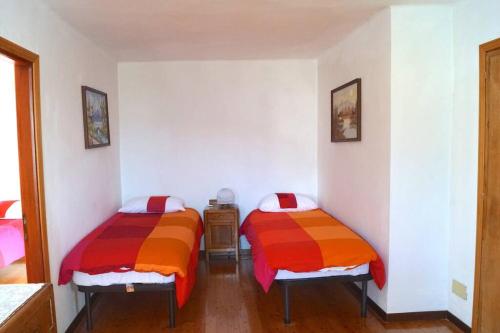 2 camas individuais num quarto com paredes brancas em Casa rustica di montagna em Gignod