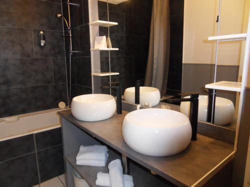 two sinks on a counter in a bathroom at Logis Hôtel Restaurant Les Aubuns in Caissargues