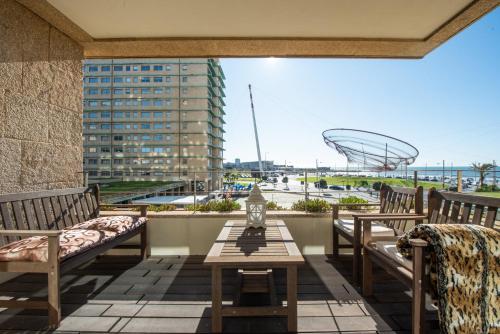 a balcony with benches and a table and a view at Apartament em condominio com Piscina in Matosinhos