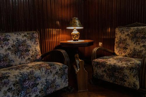 a room with two chairs and a table with a lamp at Vila Retezat Sinaia in Sinaia