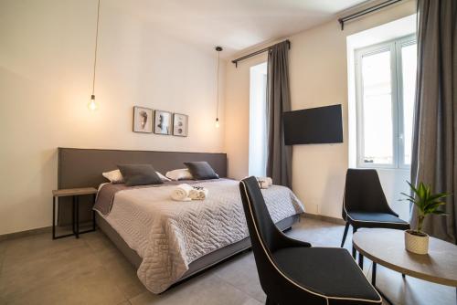 um quarto com uma cama, uma mesa e cadeiras em Plebiscitum 2.0 em Nápoles