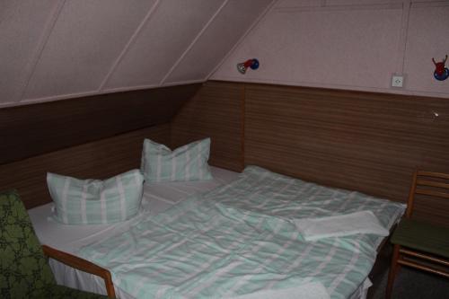 a bedroom with a bed and two pillows at Turistická chata Prachov in Jičín