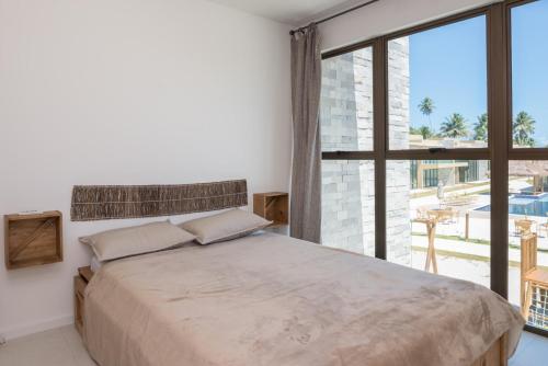 サン・ミゲル・ドス・ミラーグレスにあるCasa Morada do Toqueの大きなベッドと大きな窓のある寝室