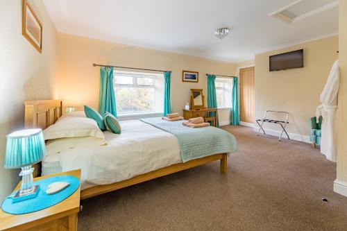 Un dormitorio con una cama grande y una ventana en Host & Stay - Poppy Cottage en Bamburgh