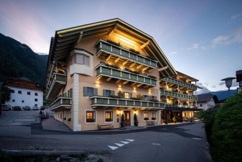 ein großes Gebäude mit seitlicher Beleuchtung in der Unterkunft Anewandter Historic Hotel in Bruneck