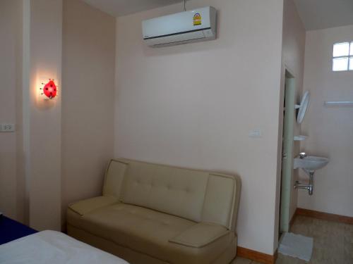 um pequeno quarto com um sofá num quarto em โรงแรมประทับใจ em Sattahip
