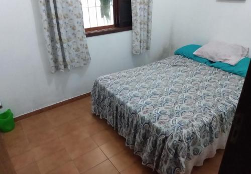 une chambre avec un lit dans une pièce avec une fenêtre dans l'établissement Casa Próximo Centro Itanhaém, à Itanhaém