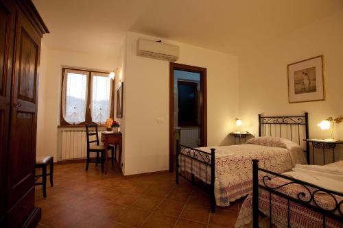 a bedroom with two beds and a table and chairs at Il Vecchio Noce in Brugnato