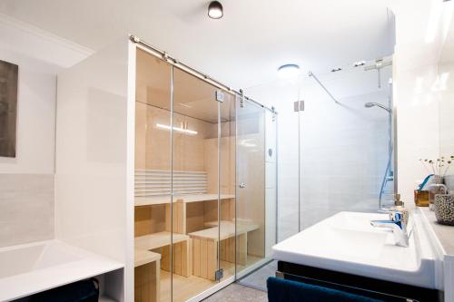 a bathroom with a glass shower and a sink at Wohnung Freiblick in Bastorf