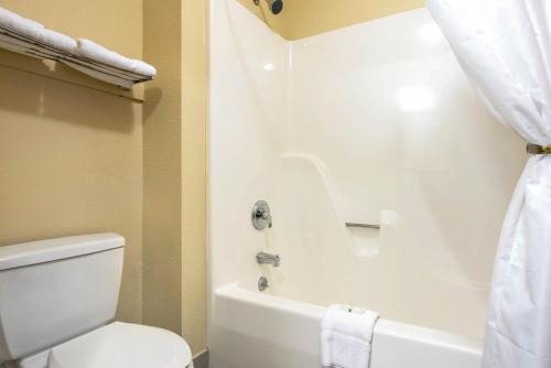 a bathroom with a white toilet and a bath tub at Quality Inn & Suites Brandenburg - Fort Knox in Brandenburg