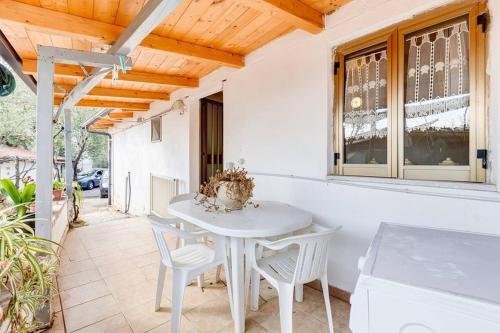 una mesa blanca y sillas en un patio en CASA VACANZE CLIO - PISCIOTTA/PALINURO, en Pisciotta