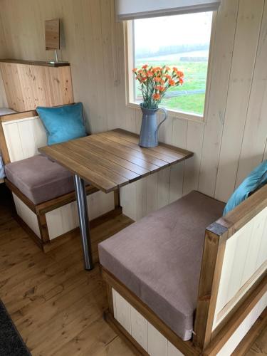 a small table and bench in a tiny house at Glamping at Holly Grove Farm in Stoke on Trent