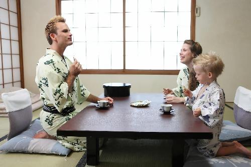 a man and a woman and a child sitting at a table at Nogami Honkan in Beppu