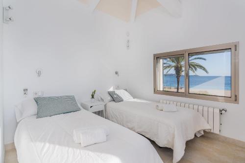 una camera con due letti e una finestra con la spiaggia di VILLA HOLLAND 11 a Port de Pollença