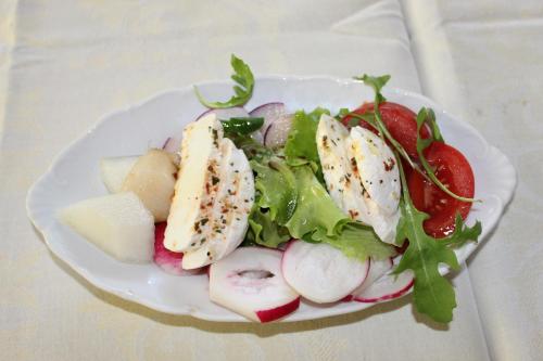a white plate with a salad with fruit and vegetables at Turistická chata Prachov in Jičín