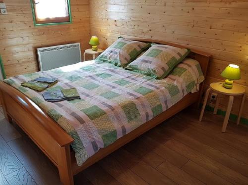 1 dormitorio con 1 cama en una cabaña de madera en Bungalow de Kermoal en Trébrivan