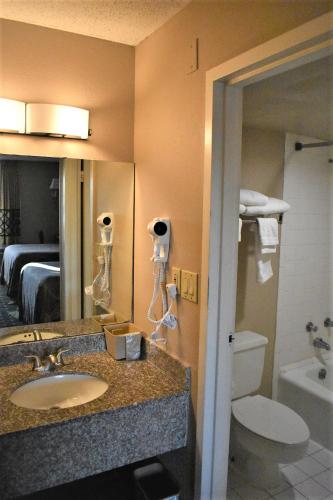 a hotel bathroom with a sink and a toilet at Super 8 by Wyndham Ocala I-75 in Ocala