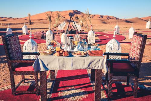 a table with food on it in the desert at Luxury Desert Camp Amanar in Merzouga