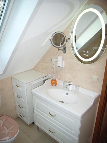 a bathroom with a white sink and a mirror at Ostsee Hotel-Pension An der Lindenallee in Bad Doberan